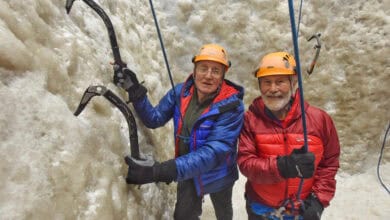 1. Climbing ice wall with ice axes and helmets in winter outdoor adventure.