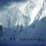 Snow-covered mountain expedition with climbers, outdoor adventure in extreme winter conditions.