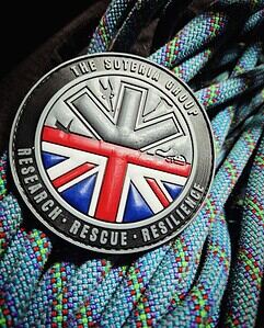 Bright outdoor rescue badge with Union Jack design on colourful woven fabric background.