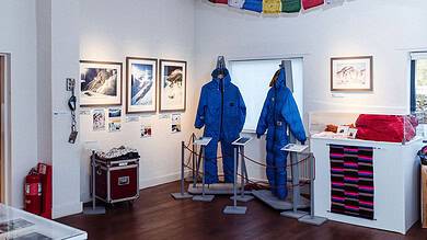 Bright indoor display of mountaineering gear, snow landscapes, and outdoor photography at Outdoor Insight gallery.