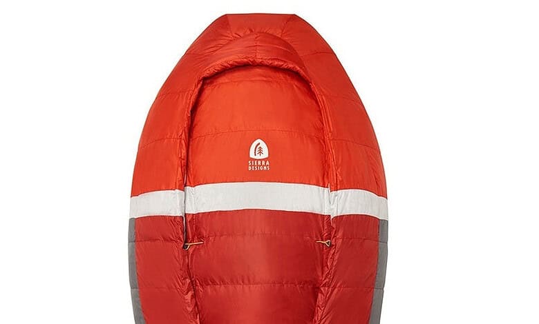 Red insulated sleeping bag with Sierra Designs logo, designed for outdoor camping adventures.