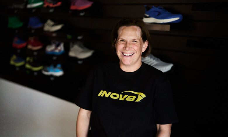 Bright smiling woman in outdoor footwear store, showcasing sports shoes and outdoor gear.