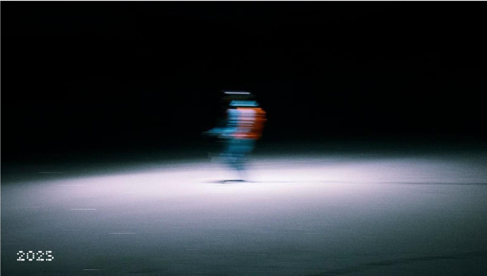 Blurred night-time ice skating figure with colourful lights for outdoor sports and winter activity enthusiasts.