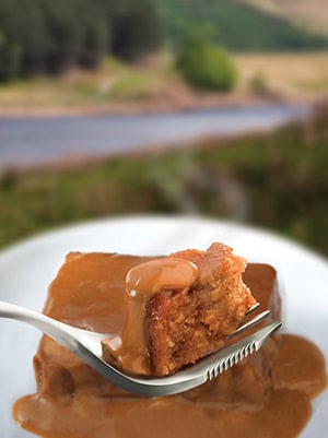 Delicious sticky toffee pudding with caramel sauce outdoors, perfect for outdoor dining and picnics.