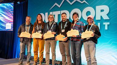 Outdoor awards ceremony with winners holding plaques at Outdoor Insight conference in UK.