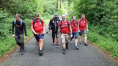 Group of hikers walking through lush forest during outdoor adventure.
