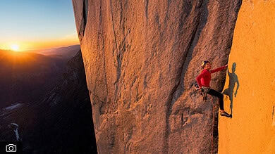 Stunning female rock climber at sunset on a mountainside in outdoor adventure setting.