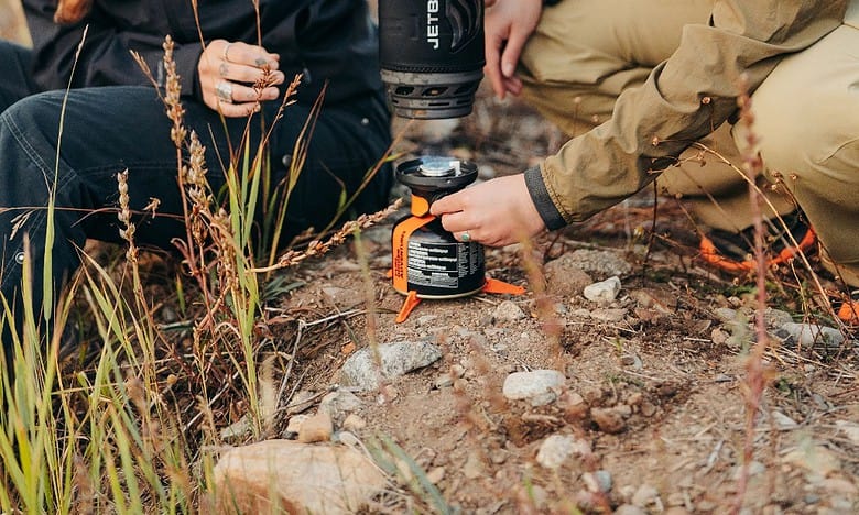 Outdoor Insight portable camping stove and cookware in outdoor setting.