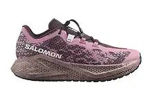 Running shoe in pink and grey with Salomon branding, designed for trail running and outdoor activiti.