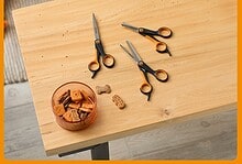Grooming scissors and pet care tools for dogs on a wooden table with treats.
