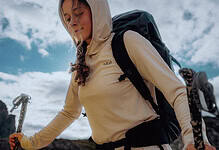 Hiker girl with backpack and trekking poles enjoying outdoor adventure.