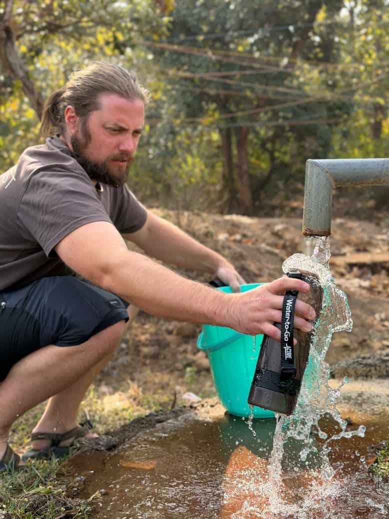 Water pump extracting fresh water from a stream outdoors.