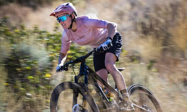Mountain biking on rugged trails with a cyclist wearing safety gear.