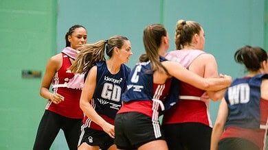 Outdoor Insight logo on netball players during a match or training session.