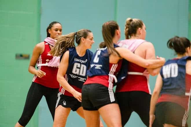 Outdoor Insight logo on netball players during a match or training session.
