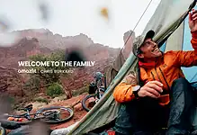Young man camping in Red Rock Canyon with mountain biking gear nearby.