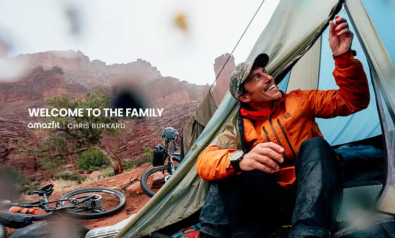 Young man camping in Red Rock Canyon with mountain biking gear nearby.
