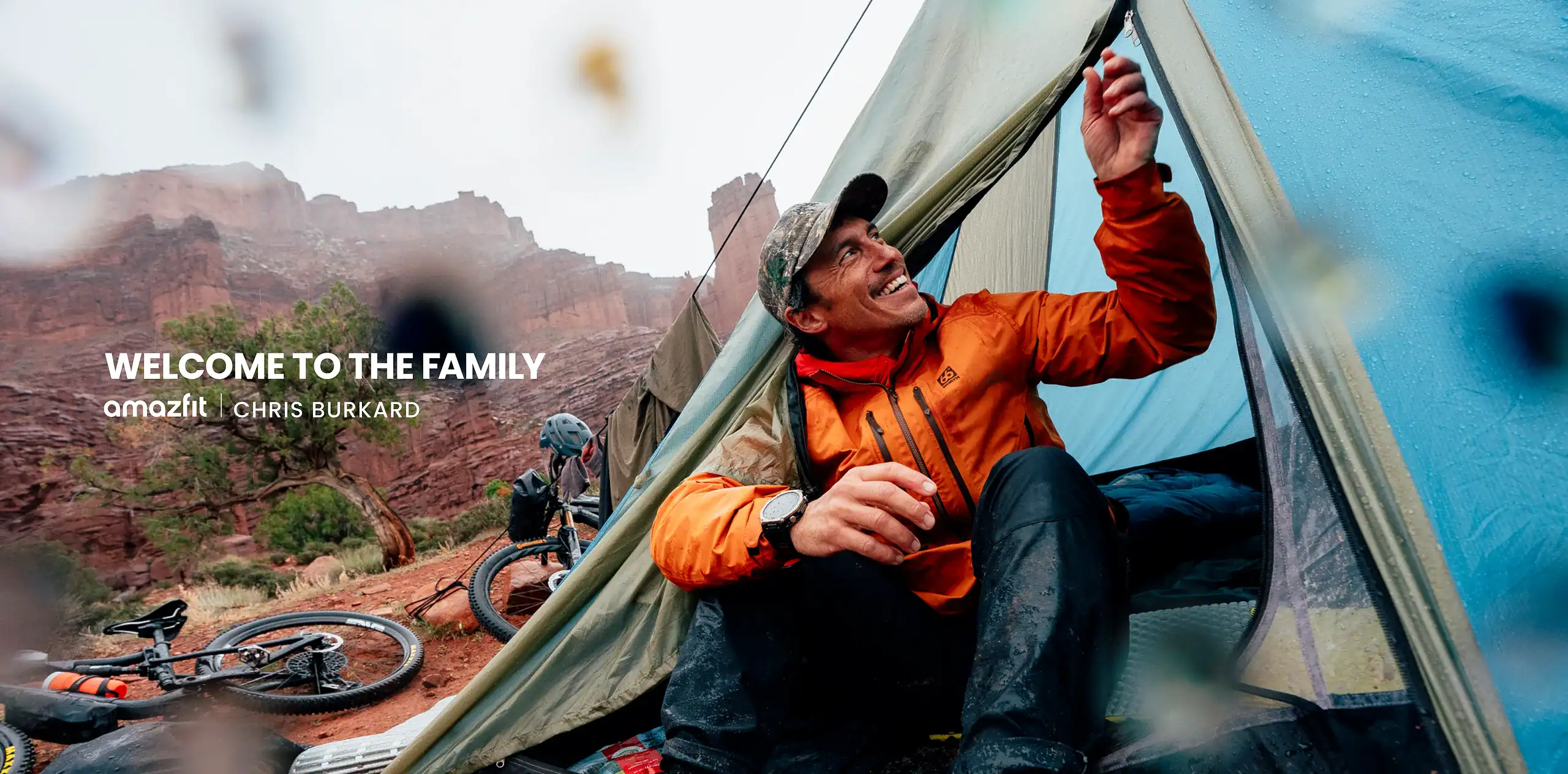 Young man camping in Red Rock Canyon with mountain biking gear nearby.
