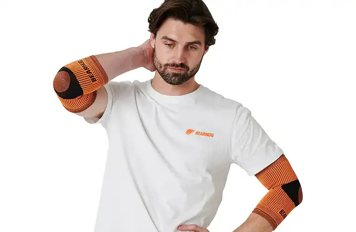 Man wearing orange elbow supports for tennis elbow recovery.