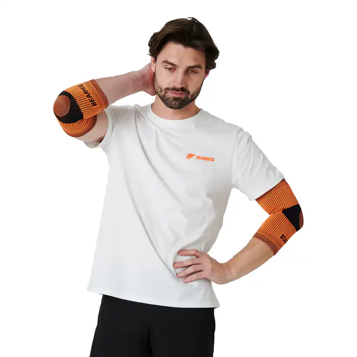 Man wearing orange elbow supports for tennis elbow recovery.