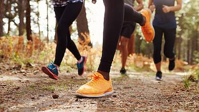 Running shoes on a forest trail during outdoor exercise.