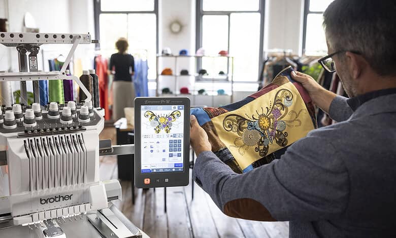 Man using embroidery machine with tablet in a craft shop.