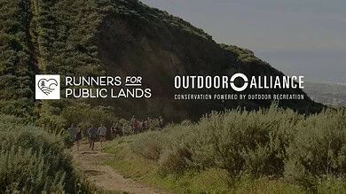Hikers walking along a trail near a green hillside with logos for Runners for Public Lands and OutdO.