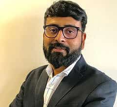Confident man with glasses in formal suit for professional profile.