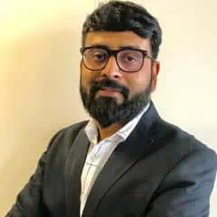 Confident man with glasses in formal suit for professional profile.