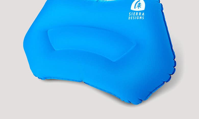 Blue inflatable pillow with Sierra Designs logo for outdoor camping.